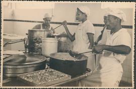 Trabalhadores servindo comida na cozinha do sanatório Getúlio Vargas