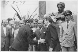 Felipe Nery Guimarães com grupo de pessoas junto a busto de Oswaldo Cruz junto ao prédio da antig...